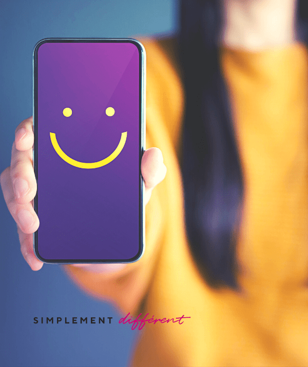 Une personne tenant à bout de bras un smartphone sur lequel nous pouvons apercevoir un dessin d'un sourire. Cette image représente la satisfaction de nos clients.